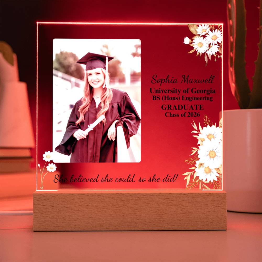 Graduation-themed decorative plaque with a photo of a graduate, text, and flowers on a red background.