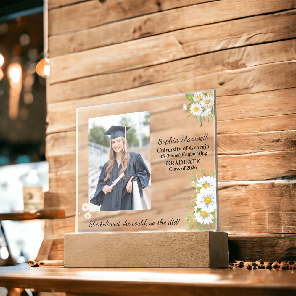Graduation-themed personalized plaque with a photo of a graduate on a wooden stand.