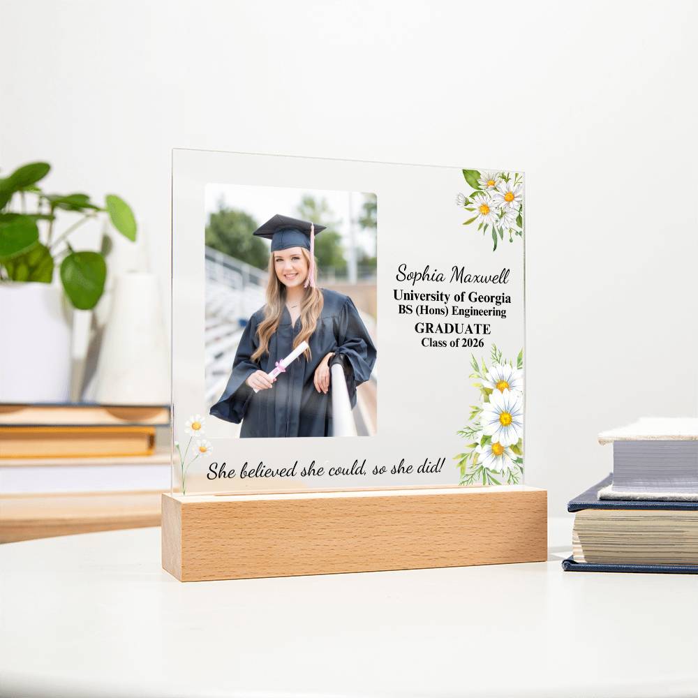 Graduation-themed photo frame with a printed photo of a graduate and text on a white surface.
