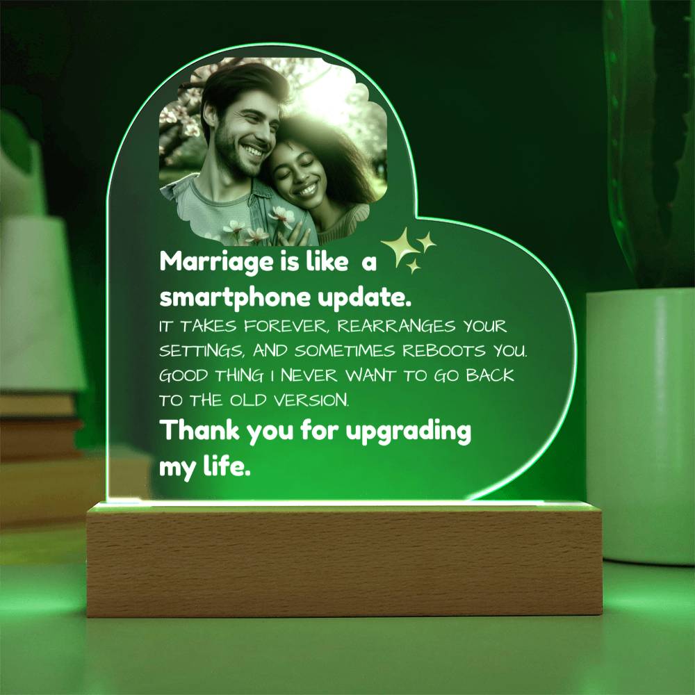 Heart-shaped LED sign with a couple's photo and humorous quote on a green background
