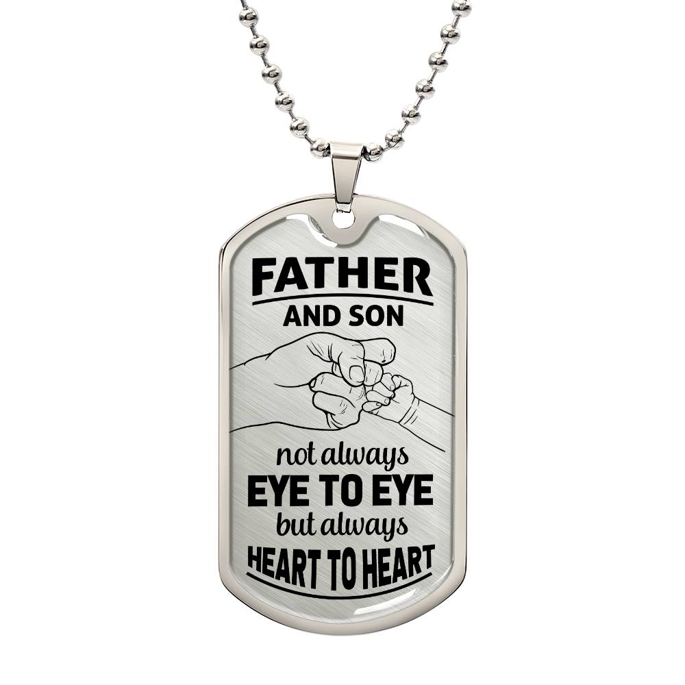This image showcases a finely detailed dog tag necklace with the poignant message, "To Dad | Not always Eye To Eye." The necklace lies on a fist bump background of son and father, adding a touch of warmth and authenticity. This piece of jewelry acknowledges the occasional differences while celebrating the deep connection and understanding between a father and child. It serves as a thoughtful and meaningful gift, reflecting the enduring love and respect that defines their relationship