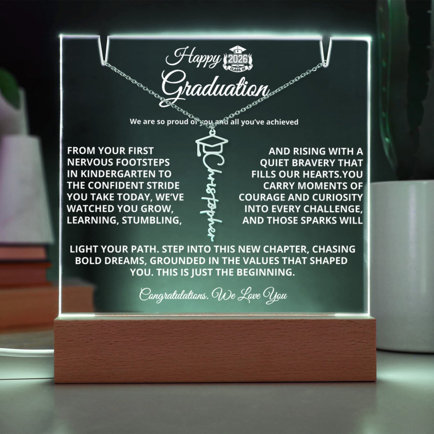 Personalized Graduation Keepsake Bundle featuring a 7" premium acrylic plaque with sharp printed photo and message on a wooden LED base (7 color modes, USB or battery), paired with a custom Graduation Cap Name Necklace (up to 11 characters) on an adjustable 18–20" chain; ships gift-ready.