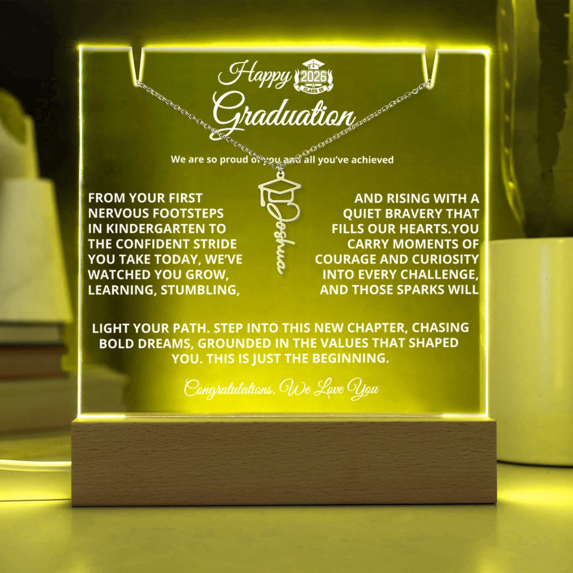 Personalized Graduation Keepsake Bundle featuring a 7" premium acrylic plaque with sharp printed photo and message on a wooden LED base (7 color modes, USB or battery), paired with a custom Graduation Cap Name Necklace (up to 11 characters) on an adjustable 18–20" chain; ships gift-ready.