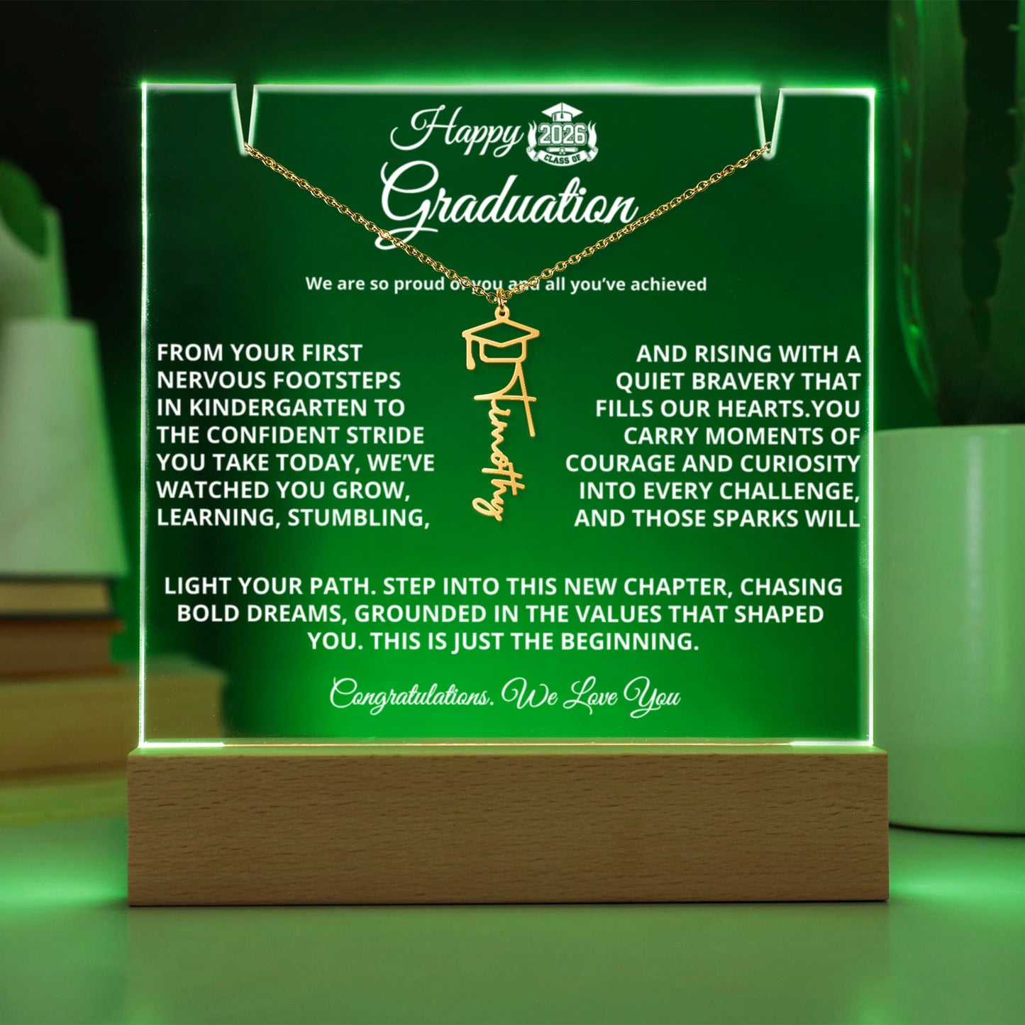 Personalized Graduation Keepsake Bundle featuring a 7" premium acrylic plaque with sharp printed photo and message on a wooden LED base (7 color modes, USB or battery), paired with a custom Graduation Cap Name Necklace (up to 11 characters) on an adjustable 18–20" chain; ships gift-ready.