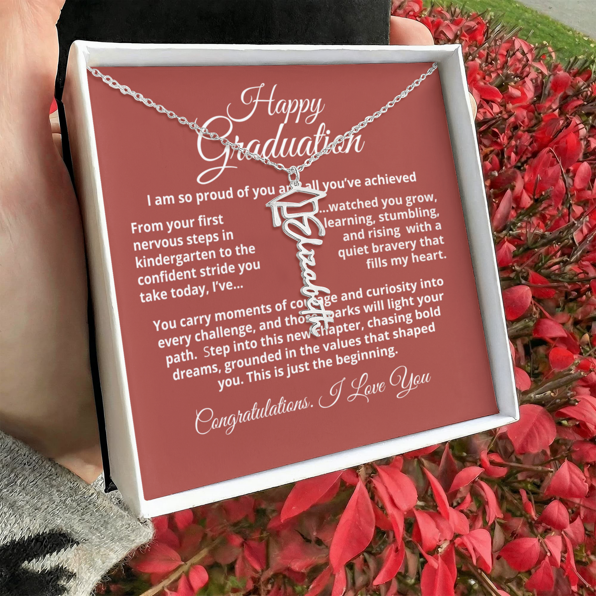 Close-up of personalized Graduation Cap Name Necklace showing scripted nameplate with small cap charm and adjustable cable chain.